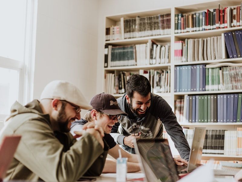 A small group of students studying together around a shared laptop